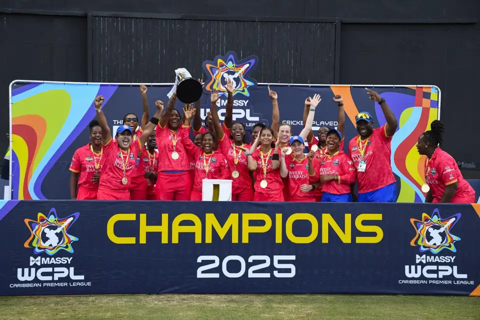 Barbados Royals players lift the trophy on the podium in front of a MASSY WCPL Champions 2025 banner